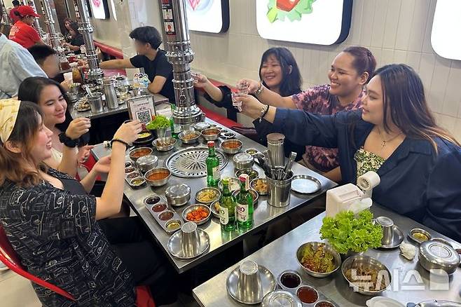 [마닐라=뉴시스] 필리핀 마닐라의 현지인 인기 한식당인 '삼겹살라맛'(Samgyupsalamat)에서 필리핀 젋은이들이 하이트진로 소주와 안주 삼겹살을 즐기고 있다. (사진= 하이트진로 제공) photo@newsis.com