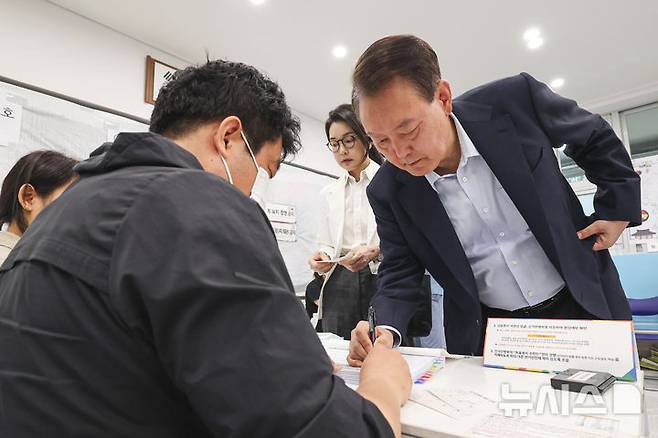 [서울=뉴시스] 박주성 기자 = 윤석열 전 대통령 내외가 제21대 대통령선거일인 3일 오전 서울 서초구 원명초등학교에 마련된 서초4동 제3투표소에서 신원 확인을 하고 있다. (공동취재) 2025.06.03. photo@newsis.com