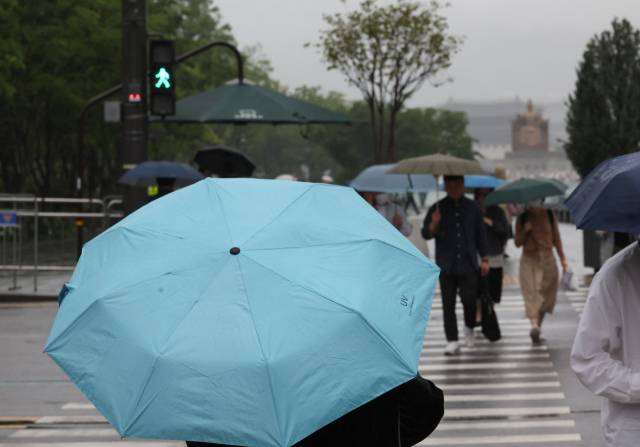 서울 광화문 부근에서 시민들이 우산을 쓰고 이동하고 있다. 연합뉴스