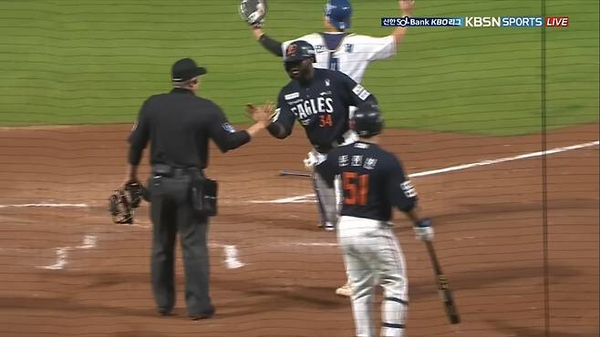 한화 외국인타자 에스테반 플로리얼(34번)이 지난달 30일 창원NC파크에서 열린 NC와 원정경기 5회초 득점한 뒤 정종수 심판위원(왼쪽)을 동료로 착각해 손뼉을 마주치고 있다. 사진출처｜티빙 중계화면 캡처