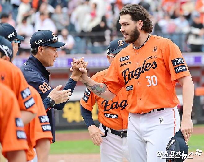 17일 오후 대전 한화생명 볼파크에서 열린 '2025 신한 SOL Bank KBO리그' SSG 랜더스와 한화 이글스의 더블헤더 1차전 경기, 한화가 8이닝 2피안타 1볼넷 18탈삼진 무실점 괴력투를 선보인 폰세의 호투에 힘입어 SSG에 1:0 승리를 거뒀다.  이날 경기에서 승리한 한화 폰세가 코칭스태프들과 하이파이브를 하고 있다. 엑스포츠뉴스 DB