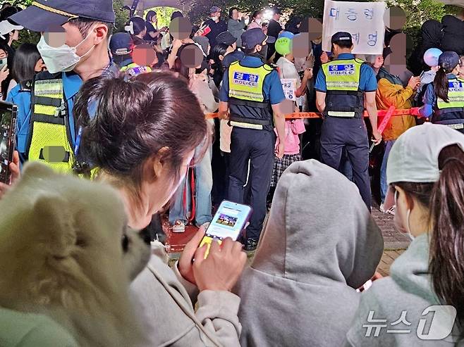 반려견을 안은 시민이 3일 이재명 대통령의 인천 계양구 사저 앞에서 당선 축하를 하고 있다. ⓒ 뉴스1 최서윤 기자