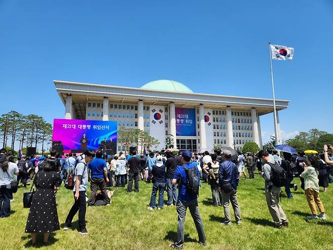 4일 오전 서울 여의도 국회의사당 앞 잔디광장에서 지지자들이 이재명 대통령 취임선서식을 보고 있다. 사진=박성현 기자