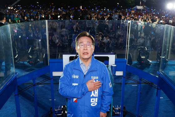 이재명 대통령 당선인이 대선을 하루 앞둔 2일 서울 여의도공원 마지막 유세에서 연설을 마친 뒤 국기에 경례하고 있다. 연합뉴스
