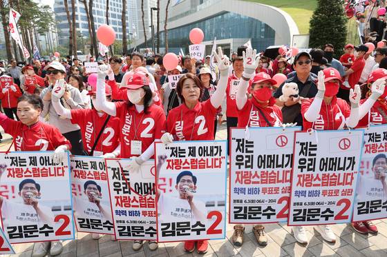 김문수 국민의힘 대선후보 운동원들이 1일 수원시 유세에서 후보 메시지가 적힌 푯말을 들고 응원하고 있다. [연합뉴스]