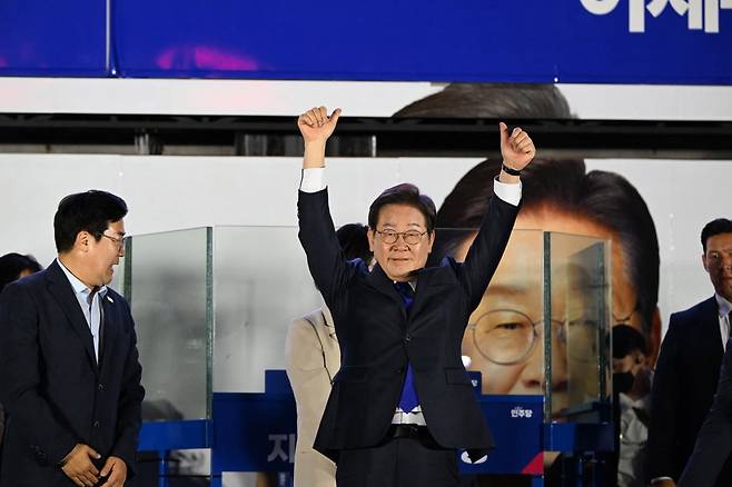 당선이 확실시된 이재명 더불어민주당 대통령 후보가 김혜경 여사와 4일 오전 서울 여의도 국회 앞을 찾아 지지자들에게 화답하고 있다. / 사진=강은구 기자