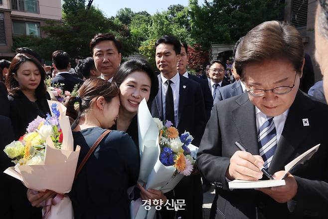이재명 대통령이 4일 오전 인천 계양구 자택앞에서 책에 서명을 하고 있다. 대통령실사진기자단