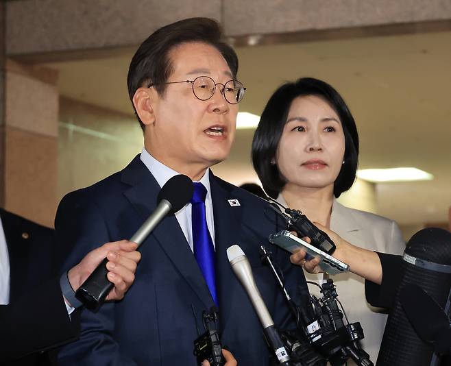 Lee Jae-myung (left) speaks alongside his wife Kim Hye-kyung in front of his residence in Incheon on Tuesday. (Yonhap)