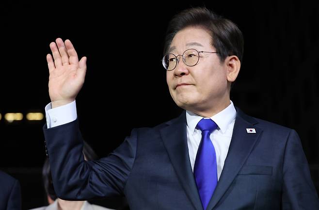 Lee Jae-myung, the president candidate of the liberal Democratic Party of Korea, waves to his supporters as he arrives at the party's headquarters in Yeouido, Seoul, early Wednesday.  (Yonhap)