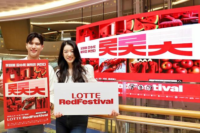 서울 송파구 신천동에 위치한 롯데월드몰 미디어 샹들리 앞에서 모델들이 롯데레드페스티벌을 홍보하고 있다. [롯데 유통군 제공]