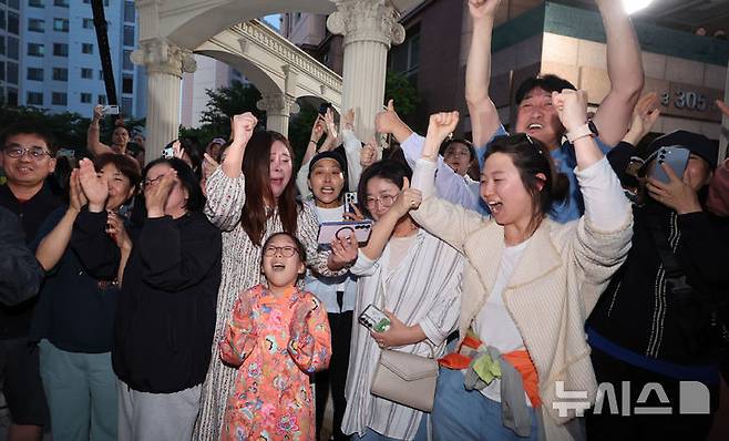 [인천=뉴시스] 전진환 기자 = 제21대 대통령 선거가 종료된 3일 오후 인천 계양구의 이재명 더불어민주당 후보의 자택 아파트 주민들이 방송사 출구조사 결과를 보며 환호하고 있다. 2025.06.03.  amin2@newsis.com