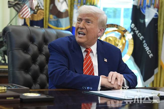 [워싱턴=AP/뉴시스]도널드 트럼프 미국 대통령이 지난달 30일(현지 시간) 백악관 집무실에서 일론 머스크 테슬라 최고경영자(CEO)를 배석한 채 기자들의 질문에 답하고 있다. 2025.05.31.