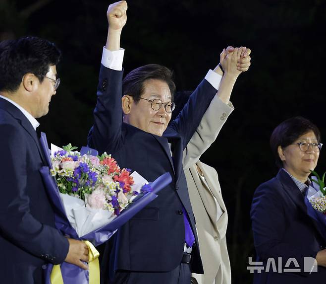 [서울=뉴시스] 조성우 기자 = 이재명 대통령이 4일 오전 서울 여의도 국회 앞에서 열린 국민 개표방송 행사에서 꽃다발을 받은 뒤 시민들을 향해 인사하고 있다.(공동취재) 2025.06.04. photo@newsis.com