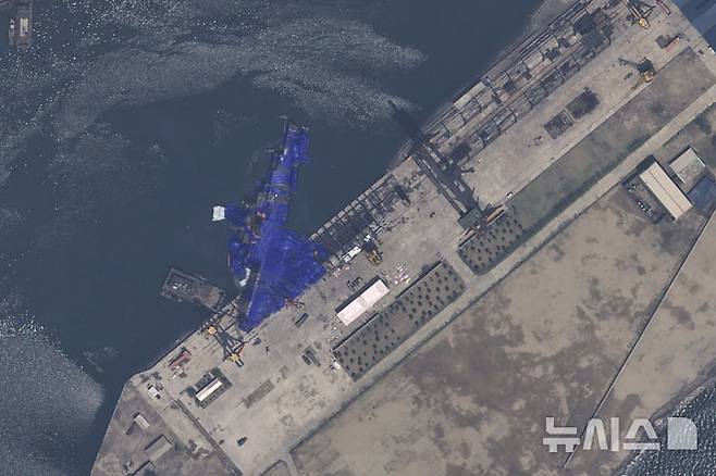 [청진=AP/뉴시스] 에어버스 DS가 제공한 22일 자 위성 사진에 북한 청진의 조선소에서 진수에 실패한 5000t 최현급 신형 구축함이 파란 방수포에 덮여 있다. 2025.05.23.