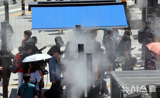 [부산=뉴시스] 하경민 기자 = 무더운 날씨를 보인 4일 부산 동구 부산역 광장 횡단보도 앞에 설치된 그늘막 아래서 시민과 관광객들이 쿨링포그를 맞으며 더위를 식히고 있다. 2025.06.04. yulnetphoto@newsis.com