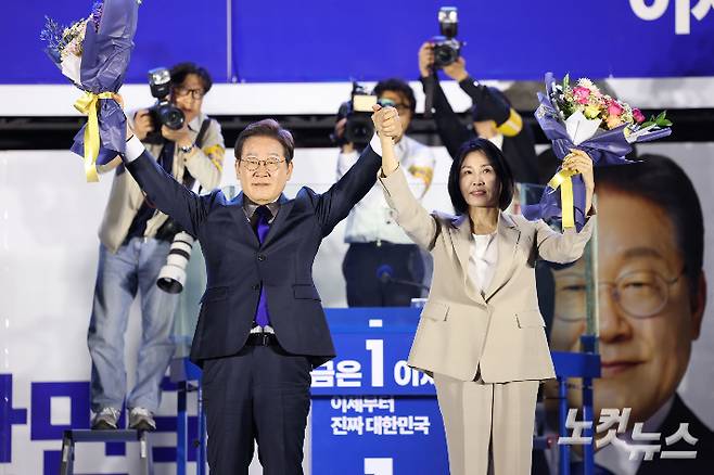 이재명 대통령과 김혜경 여사가 4일 서울 여의도 국회 앞에 마련된 더불어민주당 국민 개표방송 행사에서 꽃다발을 받은 뒤 인사하고 있다. 류영주 기자