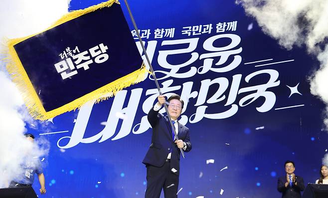 더불어민주당 이재명 대선 후보가 제21대 대통령 당선인으로 확실시되고 있다. 사진은 지난 2024년 8월18일 올림픽공원 KSPO돔에서 열린 전국당원대회에서 당대표 연임에 성공한 뒤 당기를 흔드는 모습. ⓒ연합뉴스