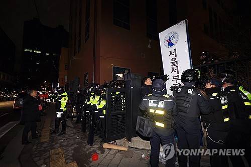 윤석열 전 대통령 지지자들이 서울 마포구 서울서부지법을 습격한 1월 19일 오전 경찰이 서부지법 후문에서 쓰러진 현판을 세우고 있다. [연합뉴스 자료사진