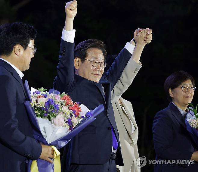 시민들에게 감사 인사하는 이재명 후보 (서울=연합뉴스) 김주성 기자 = 제21대 대통령 당선이 확실시되는 더불어민주당 이재명 대선 후보가 4일 서울 여의도 국회 인근에서 당 주최로 열린 국민개표방송 행사에 참석해 시민들을 향해 두 팔을 들어 인사하고 있다. 2025.6.4 [공동취재] utzza@yna.co.kr