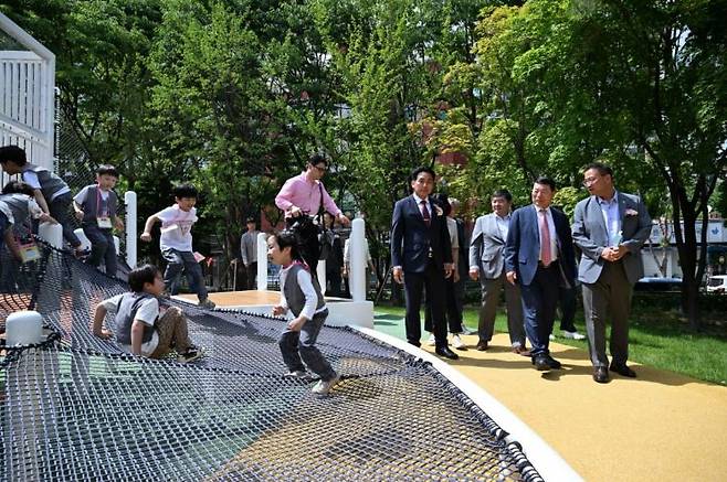 백경현 구리시장(오른쪽 두 번째)이 5일 개장한 경기도 제1호 무장애통합놀이터에서 트램펄린을 즐기는 어린이들을 살펴고 보고 있다. 구리시 제공