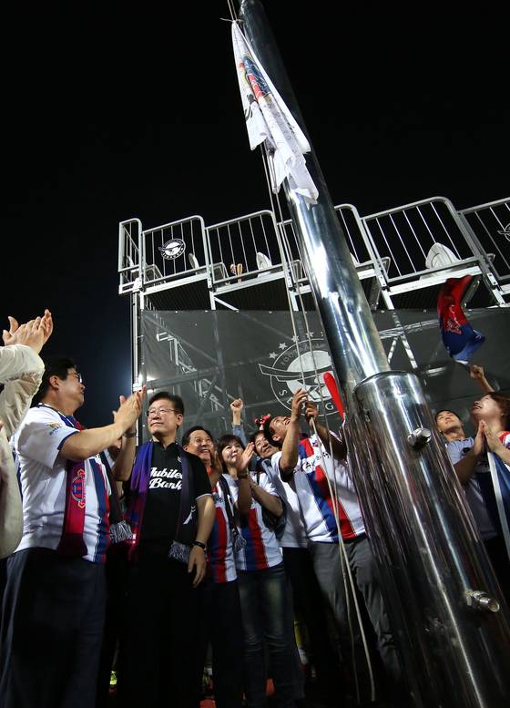 이재명 대통령(왼쪽 둘째)은 2016년 성남FC 구단주 시절 염태영 수원FC 구단주와 ‘깃발 더비’를 펼쳤다. 승리팀이 경기장에 기를 게양하는 내기다. [사진 프로축구연맹]