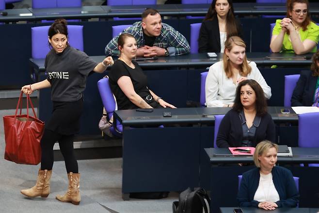 칸진 쾨크튀르크 독일 의원(왼쪽)이 4일(현지시간) 베를린 국회 본회의장에서 열린 회의에서 ‘팔레스타인’이라고 적힌 티셔츠를 입고 나타났다가 강제 퇴장당하고 있다. EPA연합뉴스