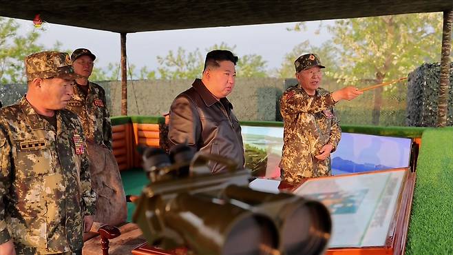 North Korean leader Kim Jong-un oversees a firing contest among military artillery units and said maximizing the demand for training is the ″shortcut″ to building a powerful army, state media reported Friday. [YONHAP]