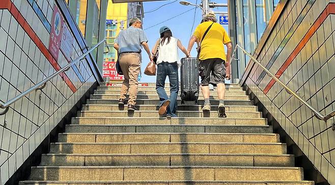 지하철역 출구 계단에서 한 여성이 무거운 짐을 들고 힘겹게 올라가자 지나던 행인이 같이 들어주고 있습니다. 출근길 훈훈한 모습을 보며 행복한 기분이 드는 날이었습니다. 이충우 기자