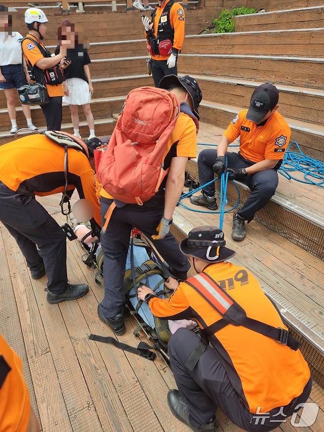 6일 오후 제주 성산일출봉 정상에서 소방대원들이 급성뇌경색으로 쓰러진 관광객을 구조하고 있다.(제주소방안전본부 제공. 재판매 및 DB 금지)