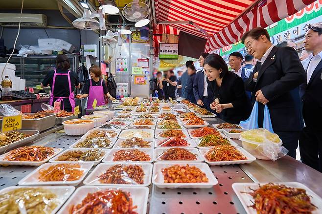 이재명 대통령과 부인 김혜경 여사가 6일 서울 사당동 남성시장을 방문해 반찬을 고르고 있다. /대통령실