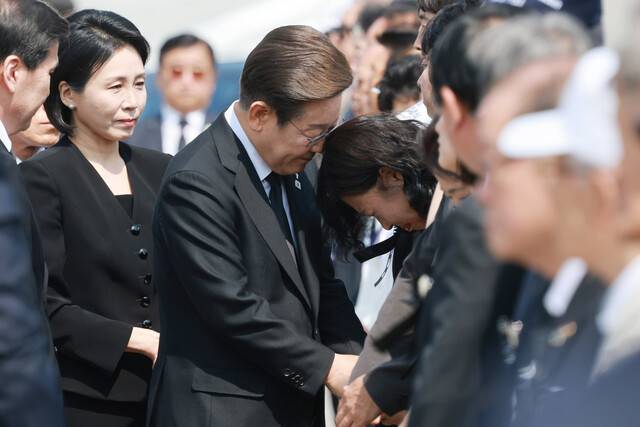 이재명 대통령이 6일 서울 동작구 국립서울현충원에서 열린 70회 현충일 추념식에 입장하며 한 유족을 위로하고 있다. 대통령실사진기자단