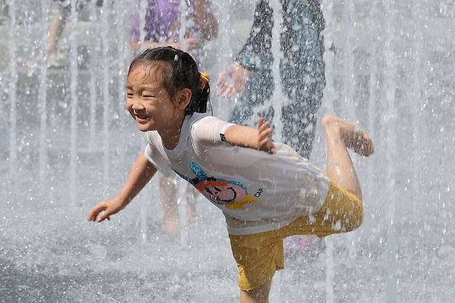 현충일인 6일 오후 서울의 한낮 기온이 29.7도까지 오르며 여름 날씨를 보였다. 서울 종로구 광화문광장 분수대을 찾은 어린이들이 물놀이를 하며 더위를 피하고 있다. 정용일 선임기자 yongil@hani.co.kr