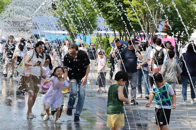 6일 오후 서울 종로구 광화문광장 분수대을 찾은 시민들이 물놀이를 하며 더위를 피하고 있다. 정용일 선임기자 yongil@hani.co.kr