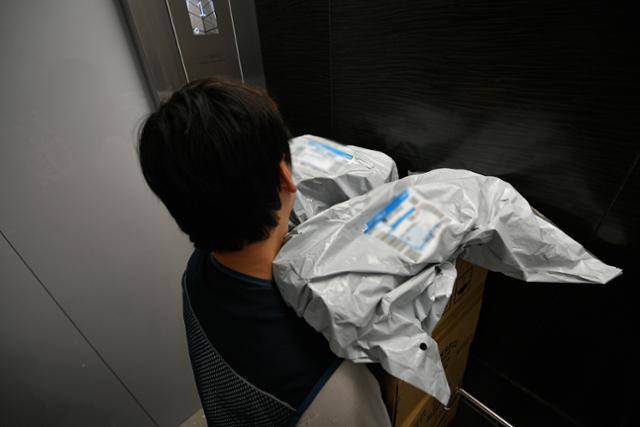 서울의 한 지역에서 2년 넘게 쿠팡 퀵플렉서 배송기사로 일하고 있는 송정민(가명)씨의 양손에 쿠팡 배송 물품이 들려 있다. 배송 업무 틈틈이 '반품 물건'도 수거하던 송씨는 "보통 고객분들이 반품 제품을 그냥 문 앞에 두실 때가 있는데, 배송된 물건인지 반품 물건인지 헷갈릴 때가 많다"며 "(비닐이나 박스) 겉에 '반품'이라고만 적어주셔도 큰 도움이 된다"고 했다. 남동균 인턴기자