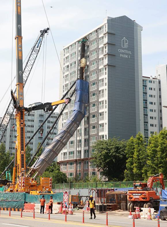 인근 아파트 8층부터 15층까지 건물 벽면에 기댄 채 쓰러져 있는 천공기. [사진=용인특례시]