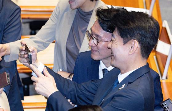 김민석 총리 후보자(가운데)가 5일 국회에서 민주당 한민수 의원과 셀카를 찍고 있다. [뉴스1]