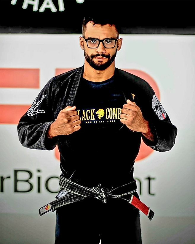 제29회 코파 프라임 1차 대회 블랙벨트 은메달리스트 산데르 호드리게스 다시우바가 2025년 5월 주짓수 도복 안에 입은 블랙컴뱃 티셔츠를 보여주고 있다. 사진@sander.nerdbjj