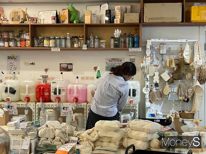 서울 마포구 한 제로웨이스트 상점에서는 리필스테이션을 운영하며 재활용이 어려운 우유팩과 병뚜껑, 커피 찌꺼기 등을 수거한다. 사진은 리필스테이션에서 손님이 세제를 담고있는 모습. /사진=남동주 기자