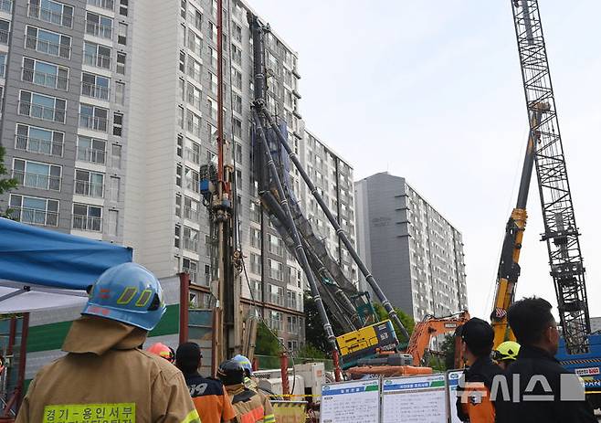 [용인=뉴시스] 김종택 기자 = 6일 경기 용인시 기흥구 서천동 인덕원~동탄 복선전철 공사 현장에서 중장비인 천공기(지반을 뚫는 건설기계)가 15층 높이 아파트 벽면에 기댄 모습으로 쓰러져 있다. 2025.06.06. jtk@newsis.com