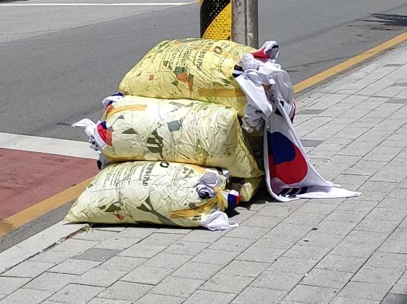 현충일인 6일 충북 청주의 한 도로변에서 다량의 태극기가 담긴 쓰레기봉투가 발견돼 경찰이 조사에 나섰다. 연합뉴스