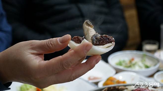 장흥산 생양파에 올린 장흥삼합. 양파의 알싸한 향취와 은은한 단맛이 삼합의 풍미를 완성시켜주는 ‘킥’의 역할을 한다               장흥｜김재범 기자 oldfield@donga.com