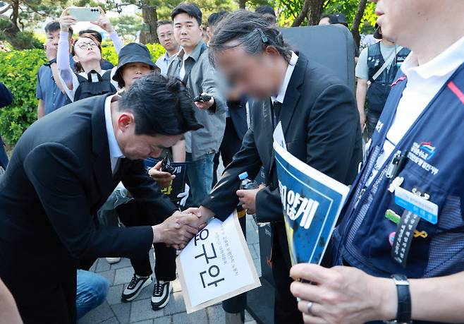강훈식 대통령비서실장이 6일 서울 용산 대통령실 청사 인근 전쟁기념관 앞에서 태안화력발전소 사고 희생자 고(故) 김충현 씨와 관련해 엄길용 공공운수노조 위원장으로부터 요구안 서한을 직접 전달받은 뒤 김씨의 유족을 만나 위로하고 있다.(사진=연합뉴스)