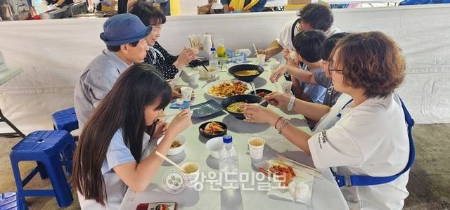 ▲ 대문어축제장을 찾은 한 가족 관광객들이 축제장에 마련된 판매장에서 대문어 회무침을 맛나게 먹고 있다.