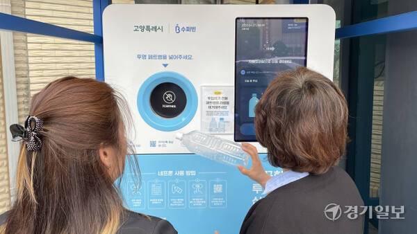 고양특례시가 폐기물 부문 온실가스 감축사업의 하나로 고양시청 주자창 한 켠에 설치한 ‘순환자원 회수로봇’에 시민들이 페트병을 넣고 있다. 신진욱기자