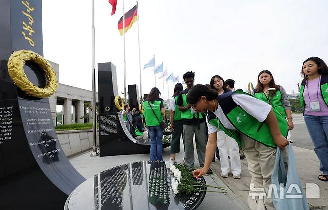 [서울=뉴시스] 홍효식 기자 = 7일 서울 용산구 전쟁기념관 평화의 광장에서 유엔참전국 후손 교류캠프 참가자들이 유엔참전용사들의 숭고한 희생을 기리며 참전기념비에 헌화하고 있다. 2025.06.07. yesphoto@newsis.com