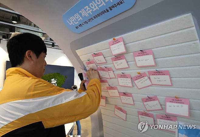 '제주와의 약속' (여주=연합뉴스) 백나용 기자 = 7일 오후 경기 신세계사이먼 여주프리미엄아울렛 WEST 분수광장에서 열린 관광 팝업스토어 '제주의 선물 인(in) 여주' 행사 참여자가 제주 여행 시 꼭 지키고 싶은 가치를 적은 '제주와의 약속' 카드를 벽면에 부착하고 있다. 2025.6.7 dragon.me@yna.co.kr