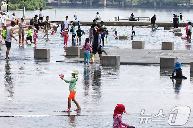 서울 낮 최고기온이 30도를 나타내는 등 전국이 초여름 날씨를 보인 8일 서울 여의도 물빛광장에서 시민들이 물놀이를 하며 더위를 식히고 있다. 2025.6.8/뉴스1 ⓒ News1 이광호 기자