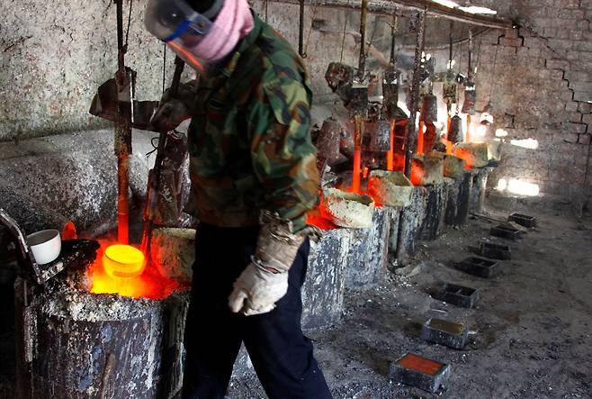 중국 내몽골 자치구 다마오 마을 인근의 희토류 제련 공장에서 한 작업자가 희토류 금속 란타늄을 주형에 부을 준비를 하고 있다. /로이터=뉴스1