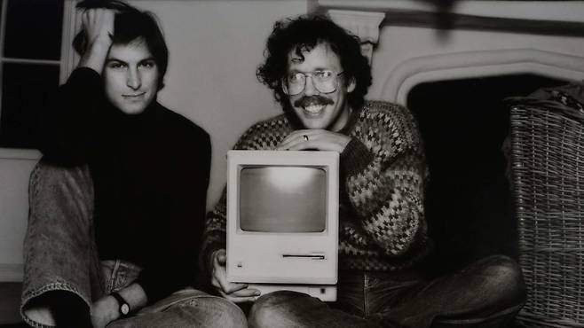 빌 앳킨슨(오른쪽)이 매킨토시 컴퓨터를 들고 스티브 잡스와 나란히 앉아 웃고 있다. 출처=연합뉴스