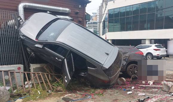 150m 돌진해 화장실 외벽 들이받은 차량. [사진=연합뉴스(부산경찰청 제공)]